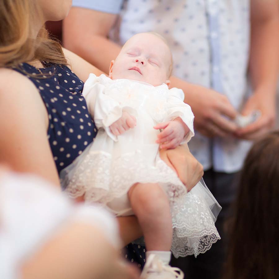 Baby in mothers arms celebrating the christening