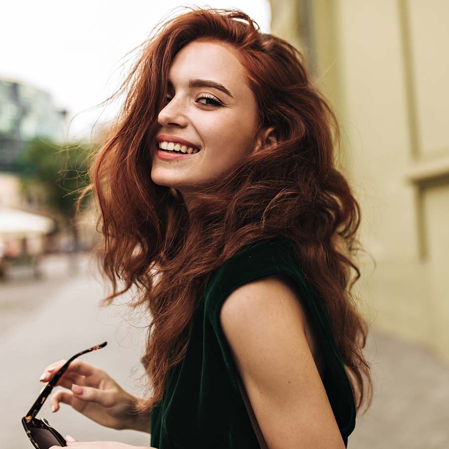 Lady with red hair walking in the street