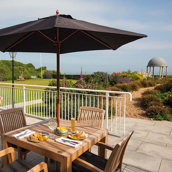 Table and chairs on outdoor terrace with sea view